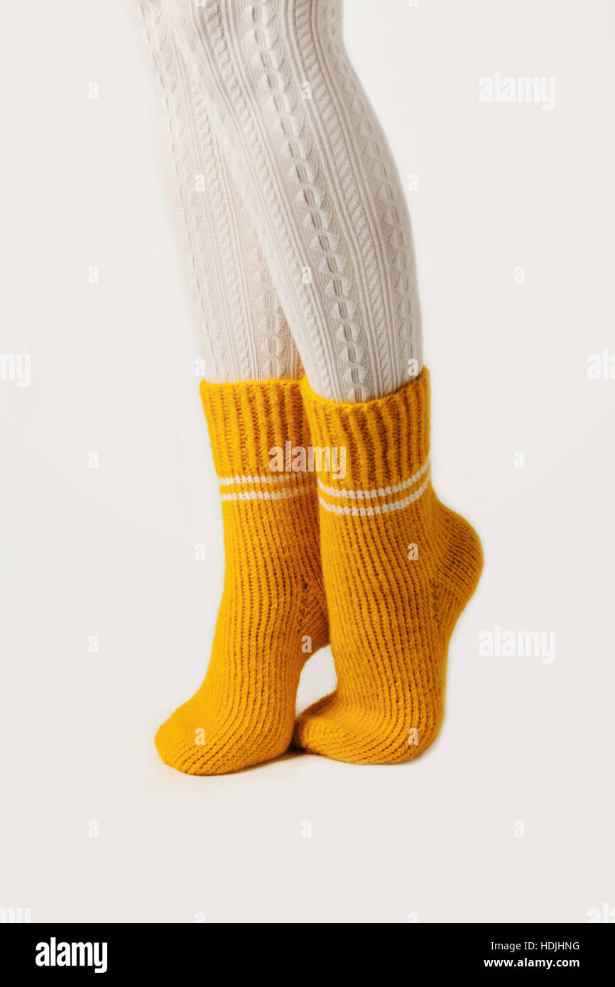 Female legs in white stockings and yellow knitted socks Stock Photo Alamy