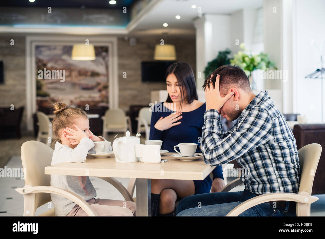 Little girl doesn't want to hear arguing of parents Stock Photo