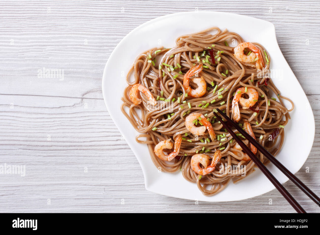Soba with shrimp and chopsticks on a plate. horizontal view from above Stock Photo