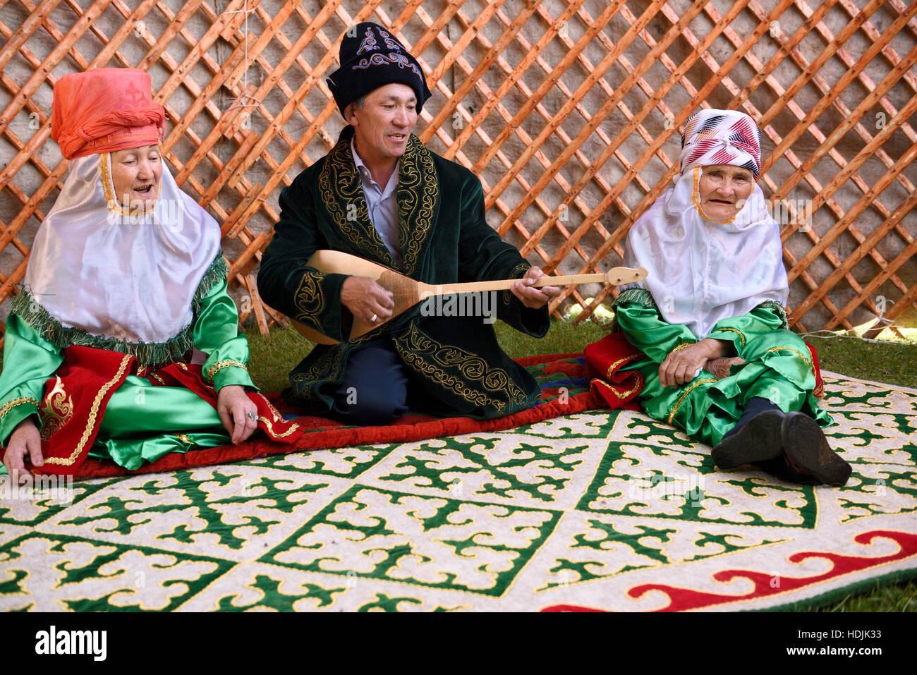 Man with dombra singing with two woman in partially constructed yurt in Saty Kazakhstan Stock Photo