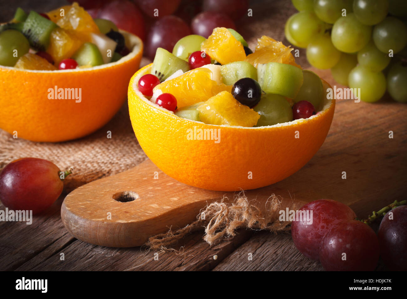 Oranges stuffed with fresh fruit salad close-up on the table. horizontal Stock Photo