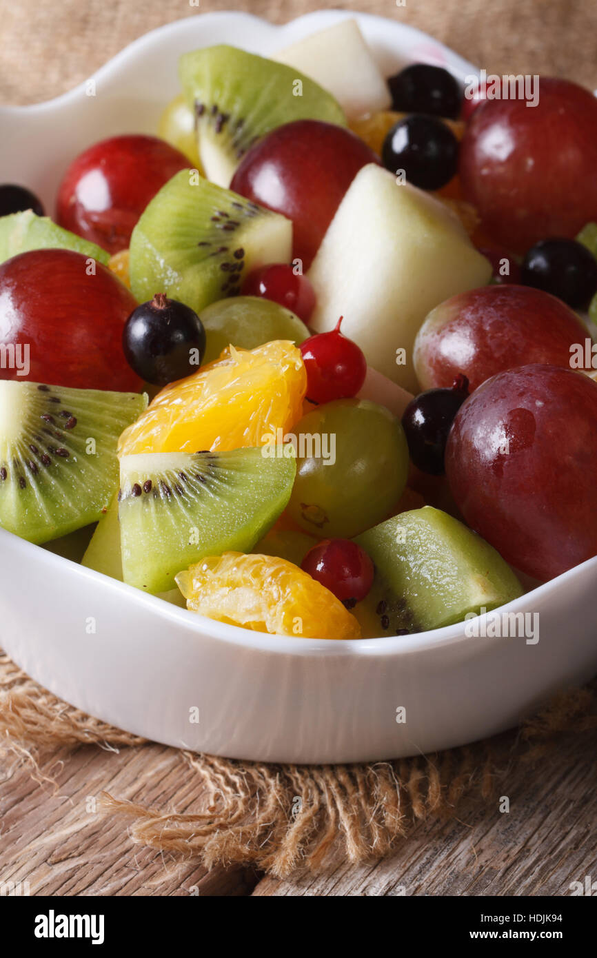 Fruit salad of oranges, kiwi, grapes and berries macro. vertical Stock Photo