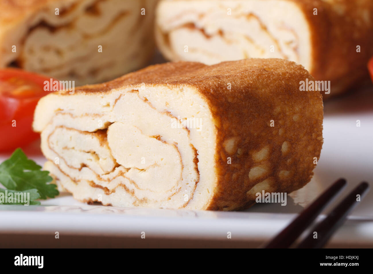 Piece of Japanese omelette tamago on a white plate close-up. horizontal Stock Photo