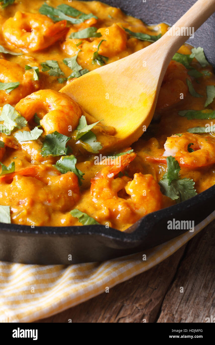 Prawns in curry sauce in a black frying pan macro. vertical, rustic style Stock Photo Alamy