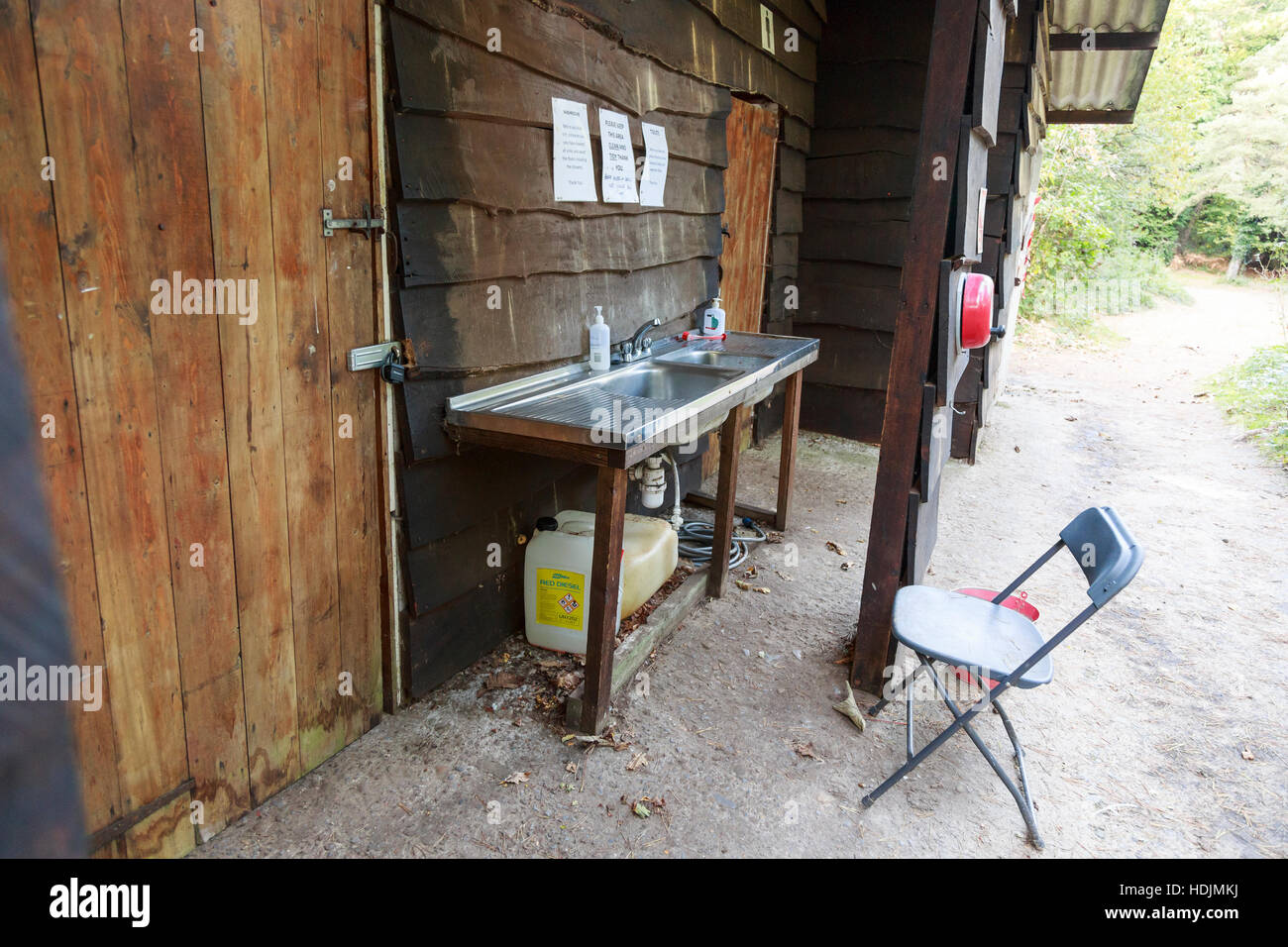 rustic wooden campsite toilet block with outside sink Stock Photo