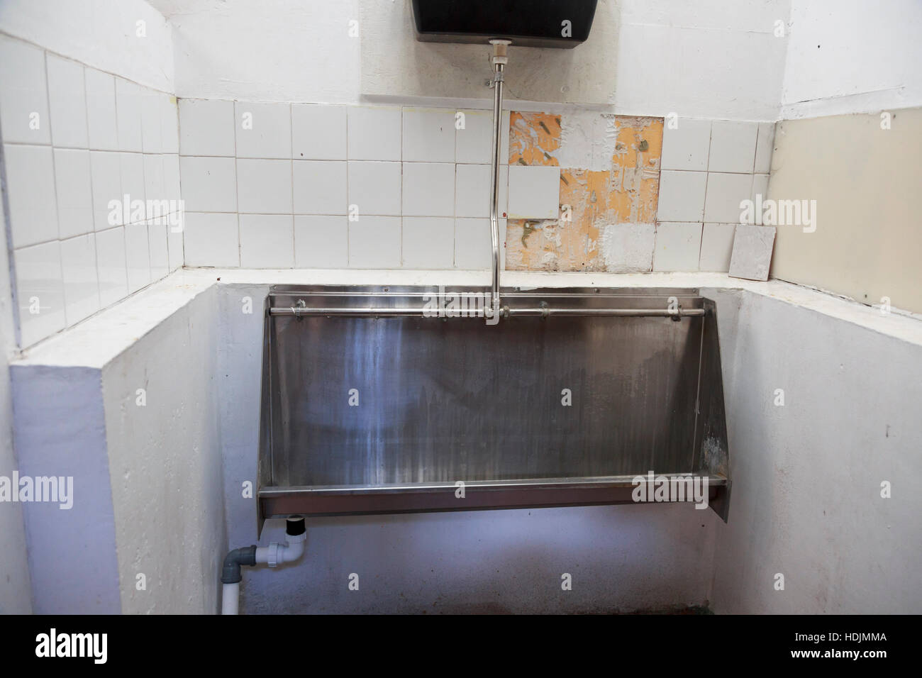 gents toilet urinal dirty with broken tiles Stock Photo