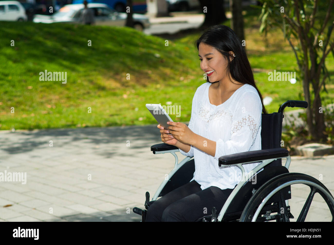 Young brunette woman sitting in wheelchair smiling with positive ...