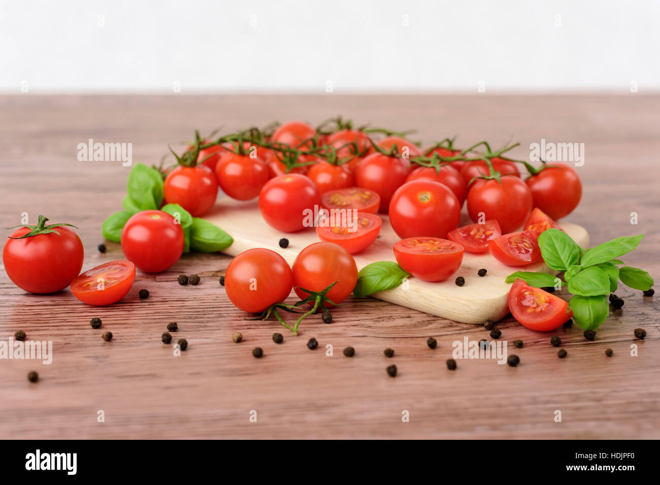 Mini tomaotes on the wooden table with bright background. Stock Photo