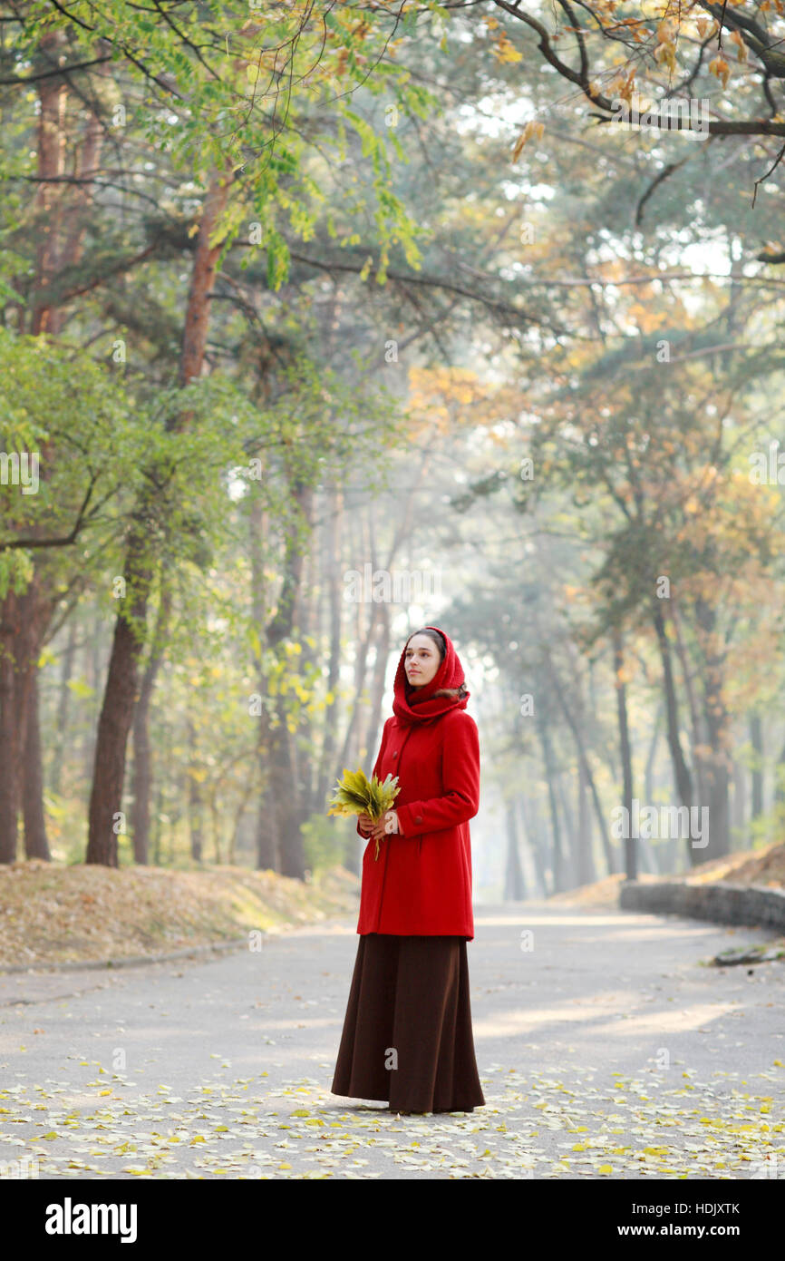 Beautiful young girl walking in autumn park Stock Photo - Alamy