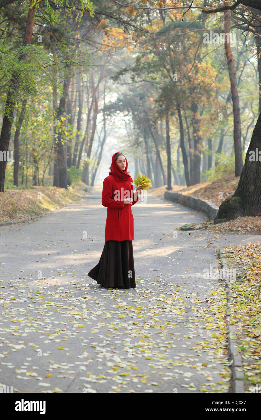 Beautiful young girl walking in autumn park Stock Photo - Alamy