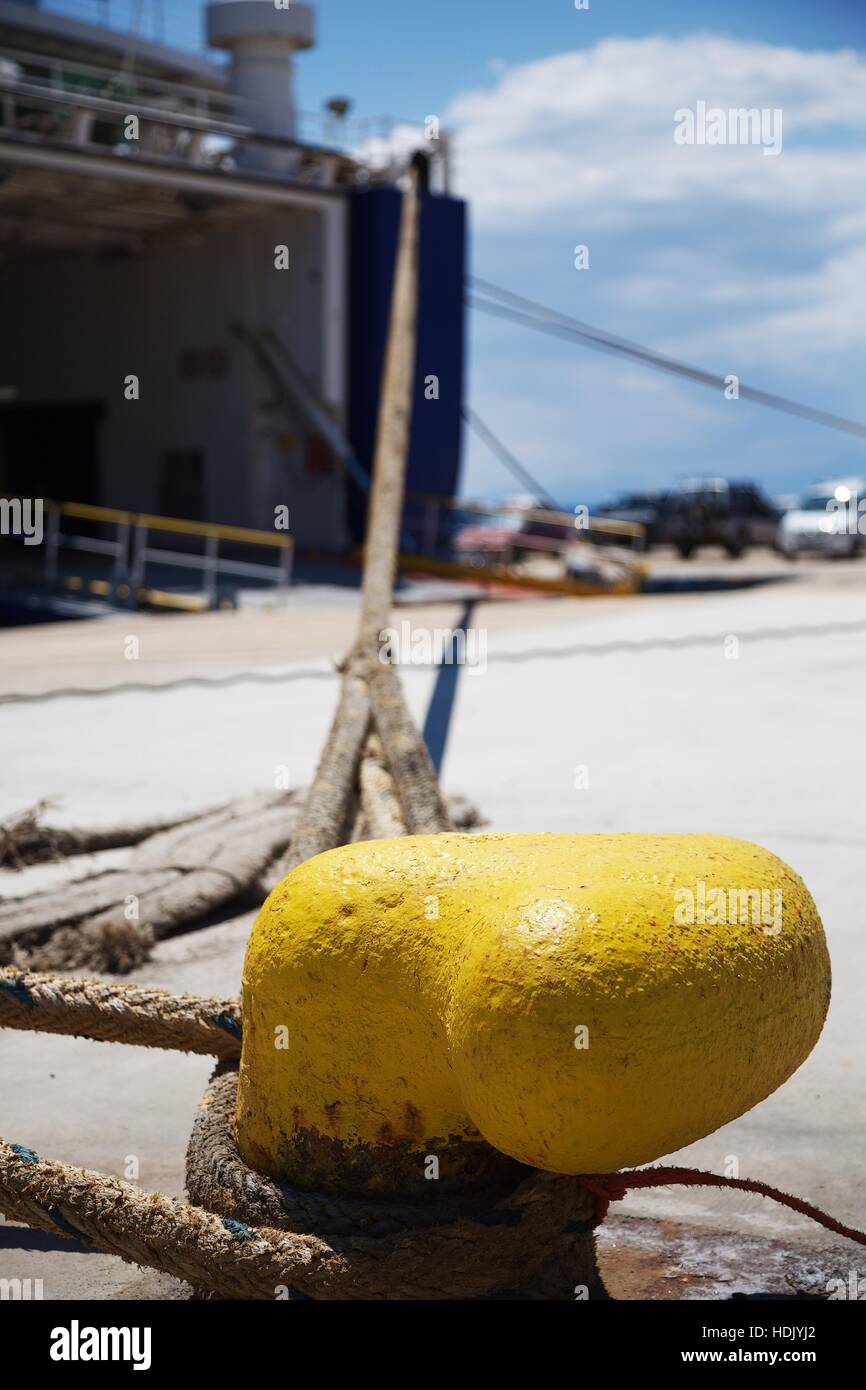 A ferry is moored to a bright yellow post in Marmari Stock Photo