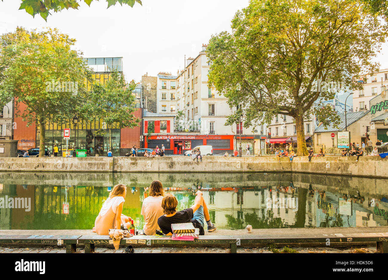 young people relaxing at canal saint-martin, quai de jemmapes Stock Photo