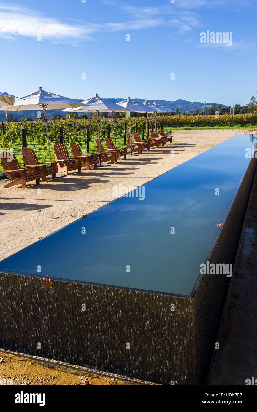 Napa, California - November 10: serene scene with a water feature reflecting the sky with chairs and a vineyard in the background. November 10 2016, N Stock Photo