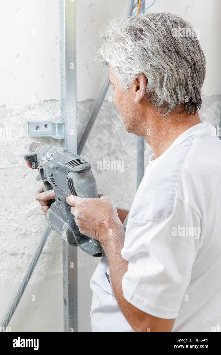 Man drilling into a wall Stock Photo Alamy