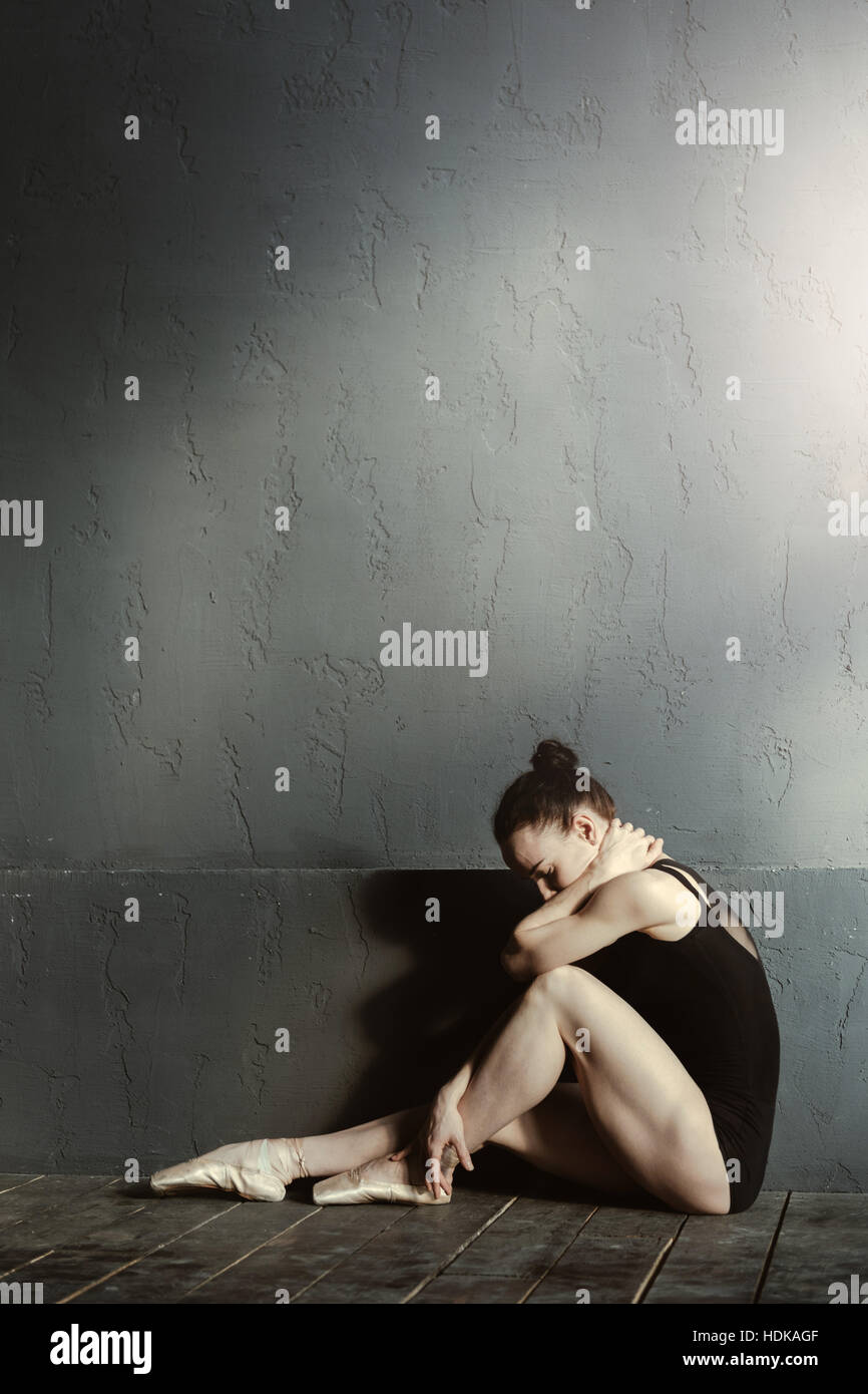 Upset ballet dancer sitting in the dark lighted room Stock Photo Alamy