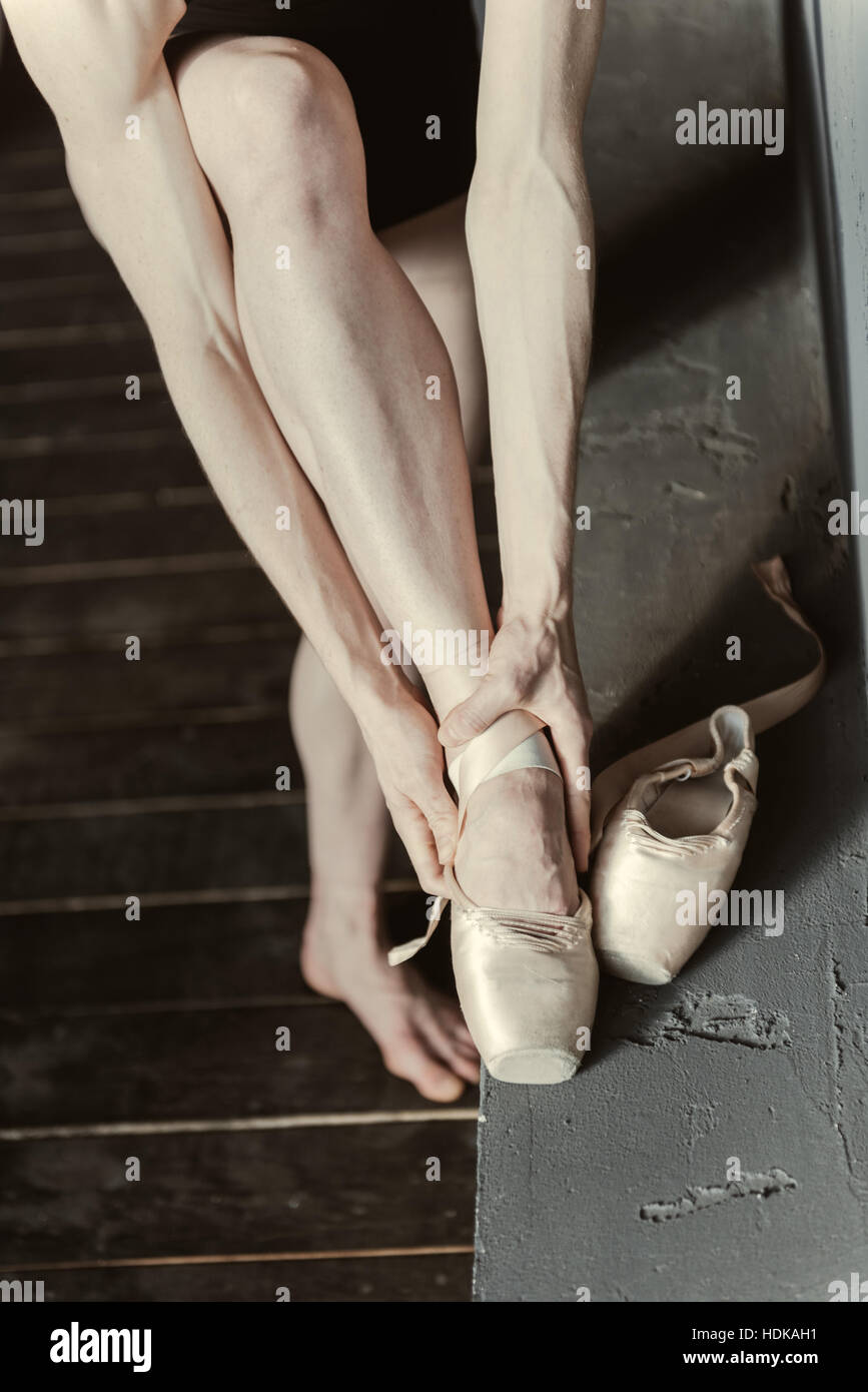 Concentrated woman wearing her ballet shoes in the studio Stock Photo