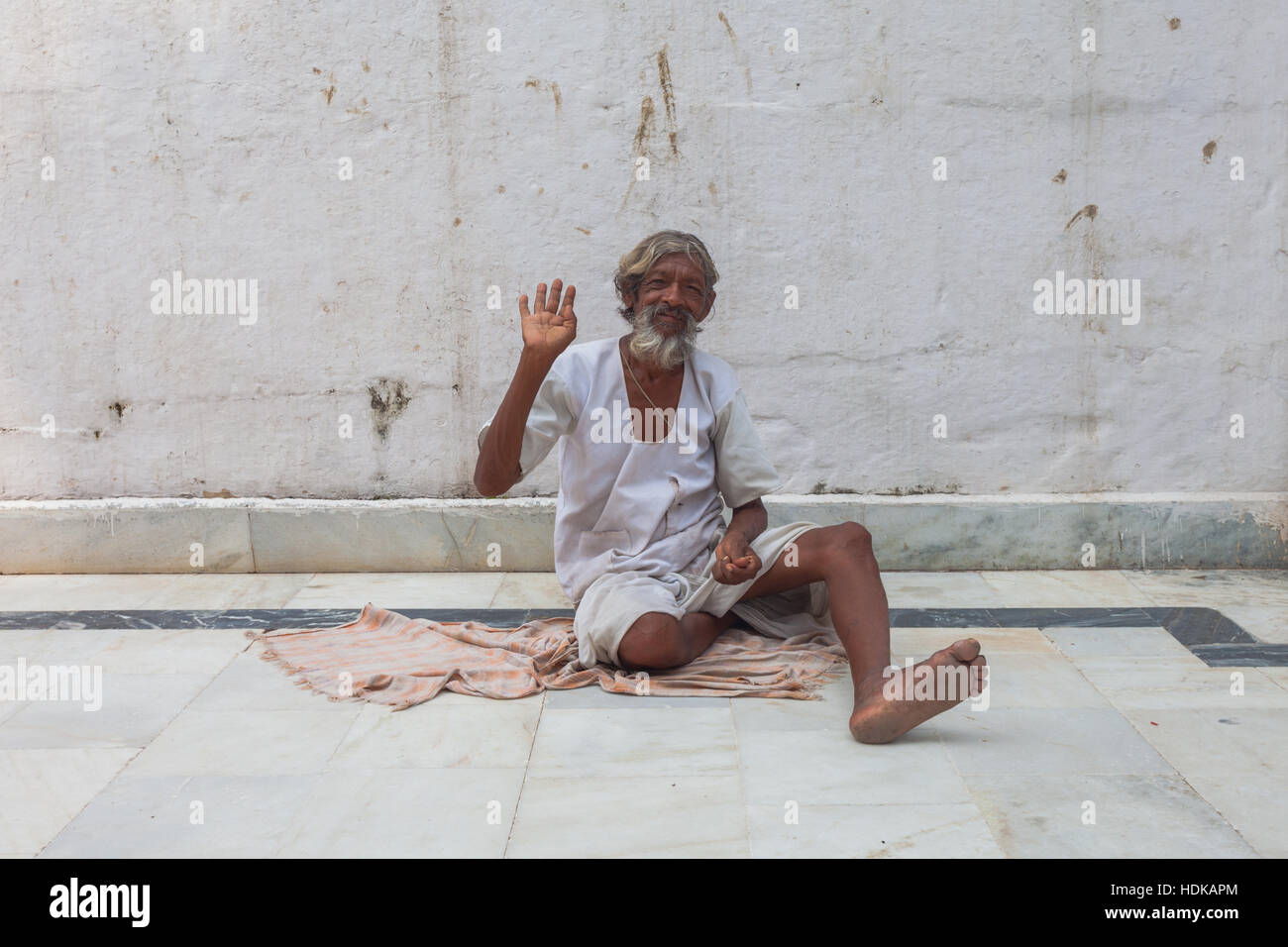 Indian man showing friendly gesture, sitting on floor, Rajasthan, India Stock Photo