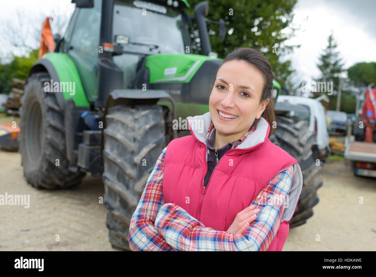beautiful farmer proudly posing in front of her tractor Stock Photo - Alamy