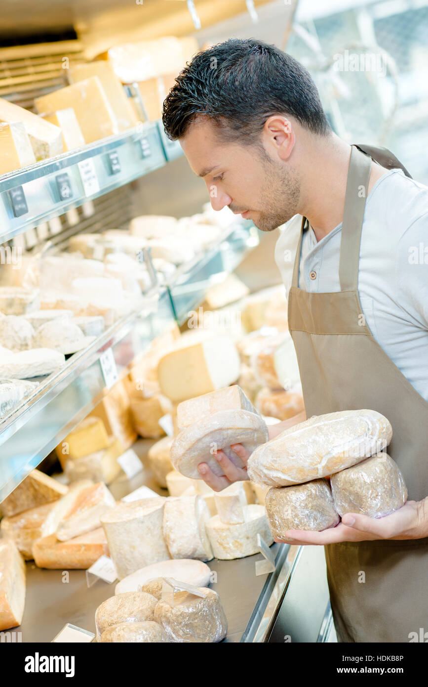 Man stocking the shelves in a cheese shop Stock Photo