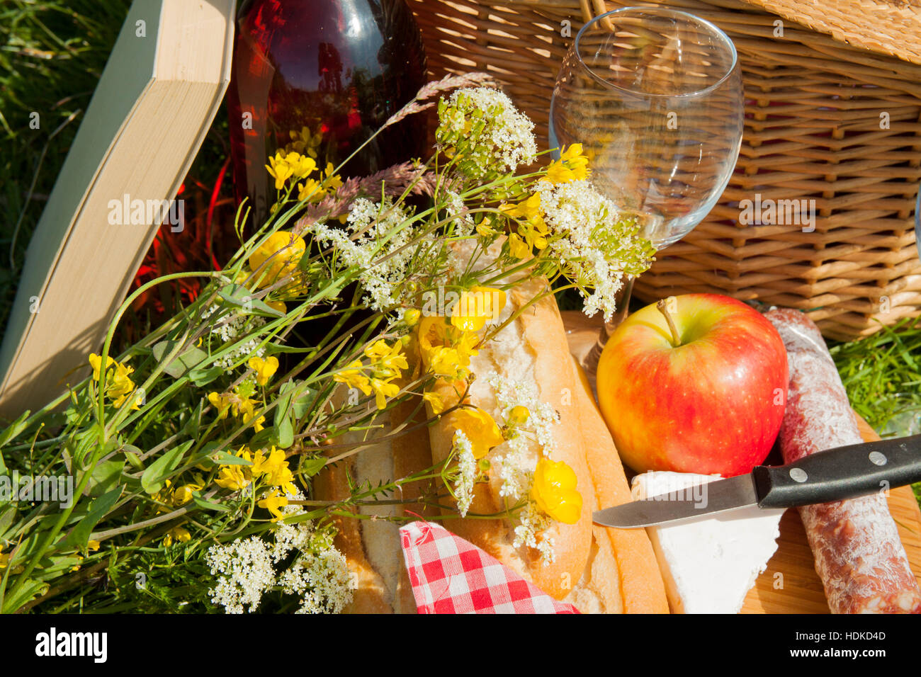 Picnic basket in the grass with tasty food and wine Stock Photo - Alamy