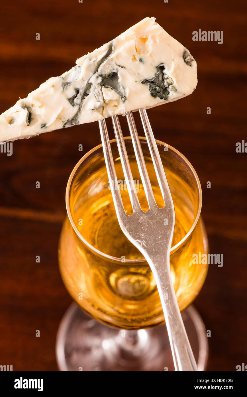 Blue cheese and white dessert wine in glass. Rustic french food as snack or appetizer. Stock Photo