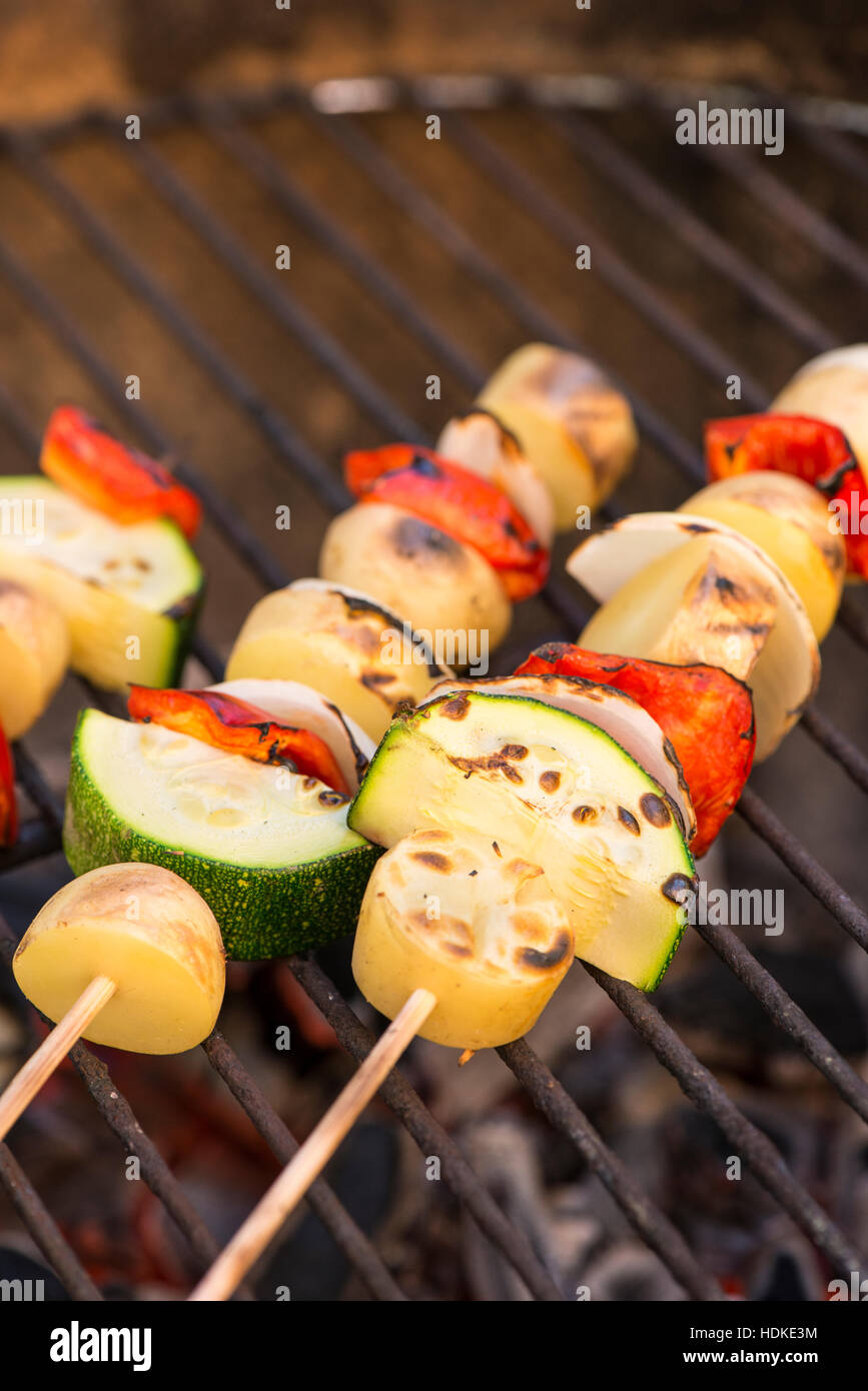 Vegetarian barbecue. Grilling vegetables on a stick. Healthy bbq food with zucchini, onion, potato and red pepper on skewer. Stock Photo