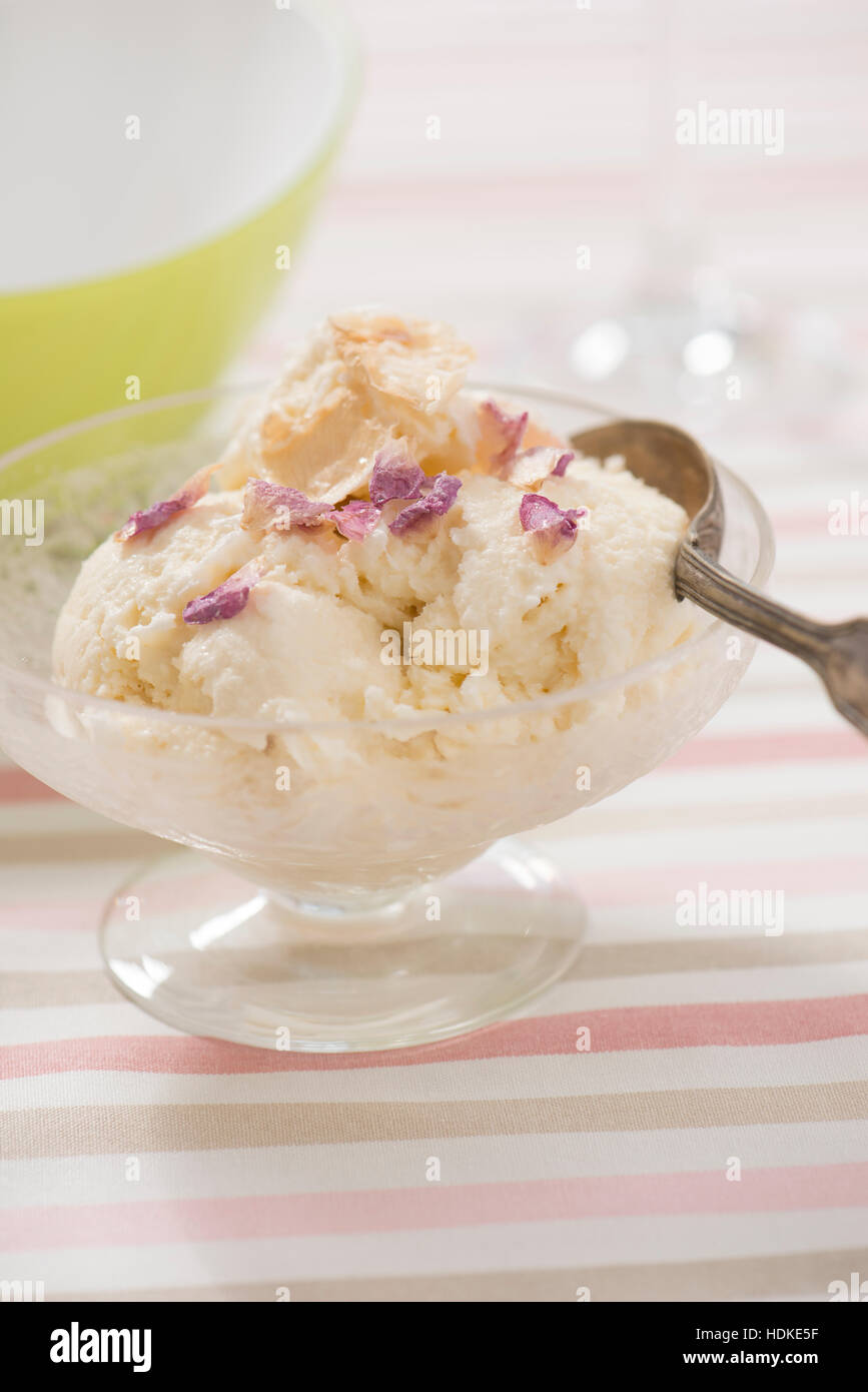 Elderflower icecream with candied rose petals. Homemade dessert served in glass bowl. Stock Photo