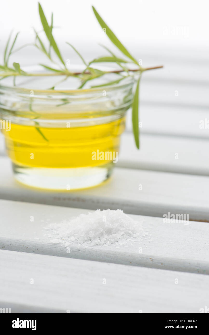 Salt on table with olive oil and rosemary in background. Stock Photo