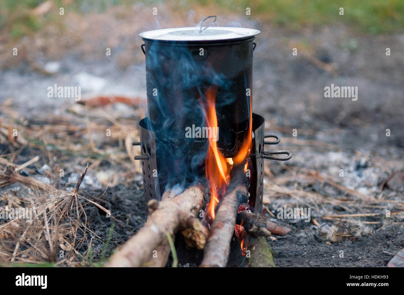 Cooking over open fire at campsite. The image of a fire in the woods on which is brewed pot. Stock Photo