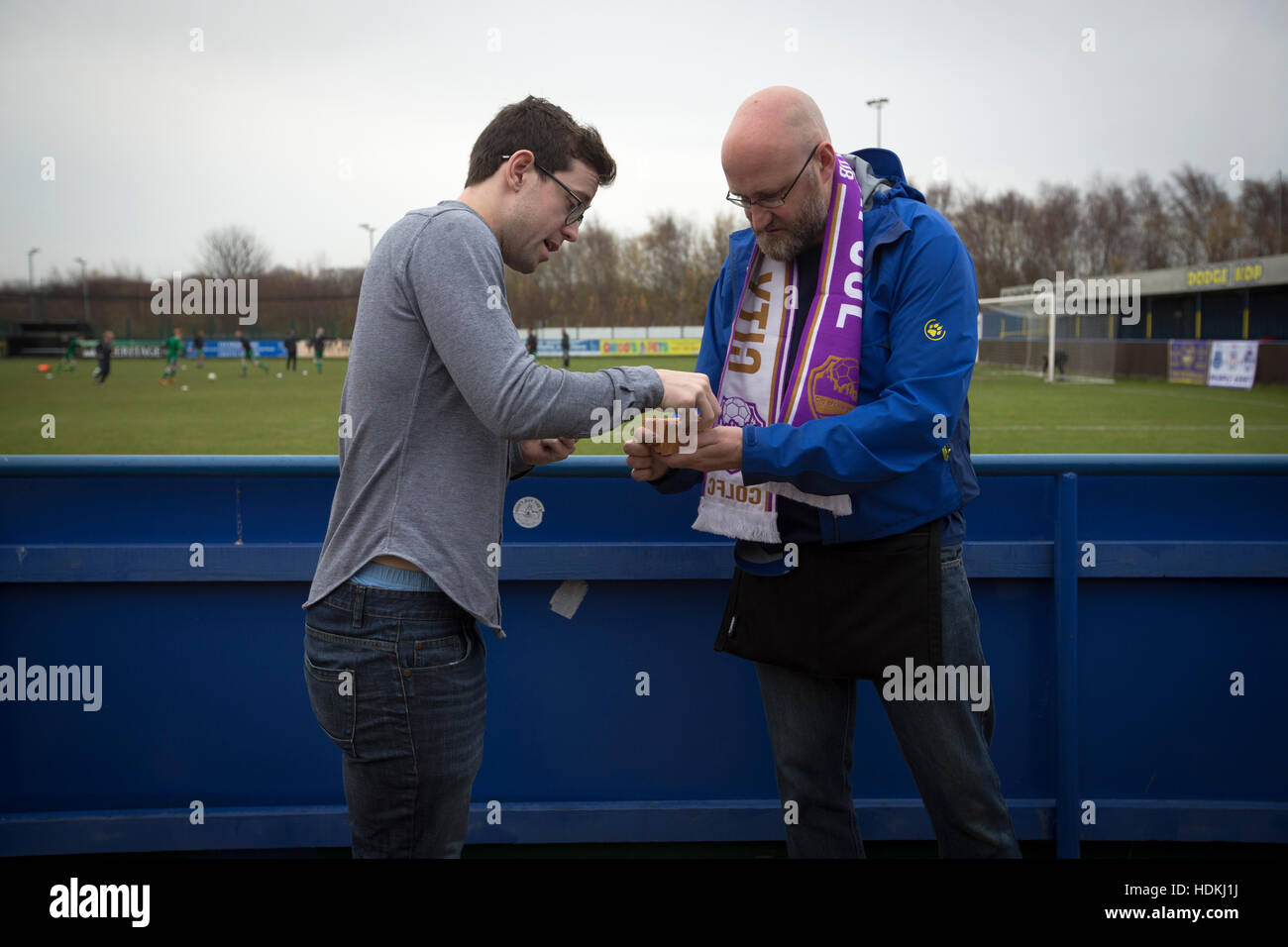 A spectator buying a 'golden goal' ticket at the Delta Taxis Stadium, Bootle, Merseyside before City of Liverpool hosted Holker Old Boys in a North West Counties League division one match. Founded in 2015, and aiming to be the premier non-League club in Liverpool, City were admitted to the League at the start of the 2016-17 season and were using Bootle FC's ground for home matches. A 6-1 victory over their visitors took 'the Purps' to the top of the division, in a match watched by 483 spectators. Stock Photo