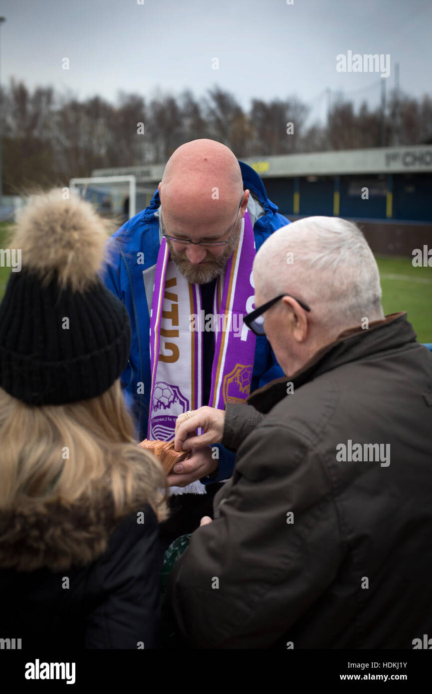 A spectator buying a 'golden goal' ticket at the Delta Taxis Stadium, Bootle, Merseyside before City of Liverpool hosted Holker Old Boys in a North West Counties League division one match. Founded in 2015, and aiming to be the premier non-League club in Liverpool, City were admitted to the League at the start of the 2016-17 season and were using Bootle FC's ground for home matches. A 6-1 victory over their visitors took 'the Purps' to the top of the division, in a match watched by 483 spectators. Stock Photo