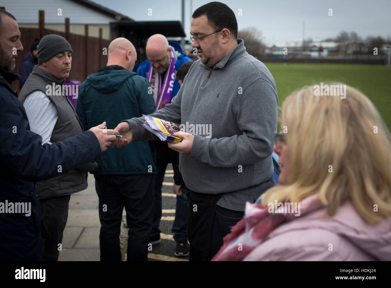 A spectator buying a match programme at the Delta Taxis Stadium, Bootle, Merseyside before City of Liverpool hosted Holker Old Boys in a North West Counties League division one match. Founded in 2015, and aiming to be the premier non-League club in Liverpool, City were admitted to the League at the start of the 2016-17 season and were using Bootle FC's ground for home matches. A 6-1 victory over their visitors took 'the Purps' to the top of the division, in a match watched by 483 spectators. Stock Photo