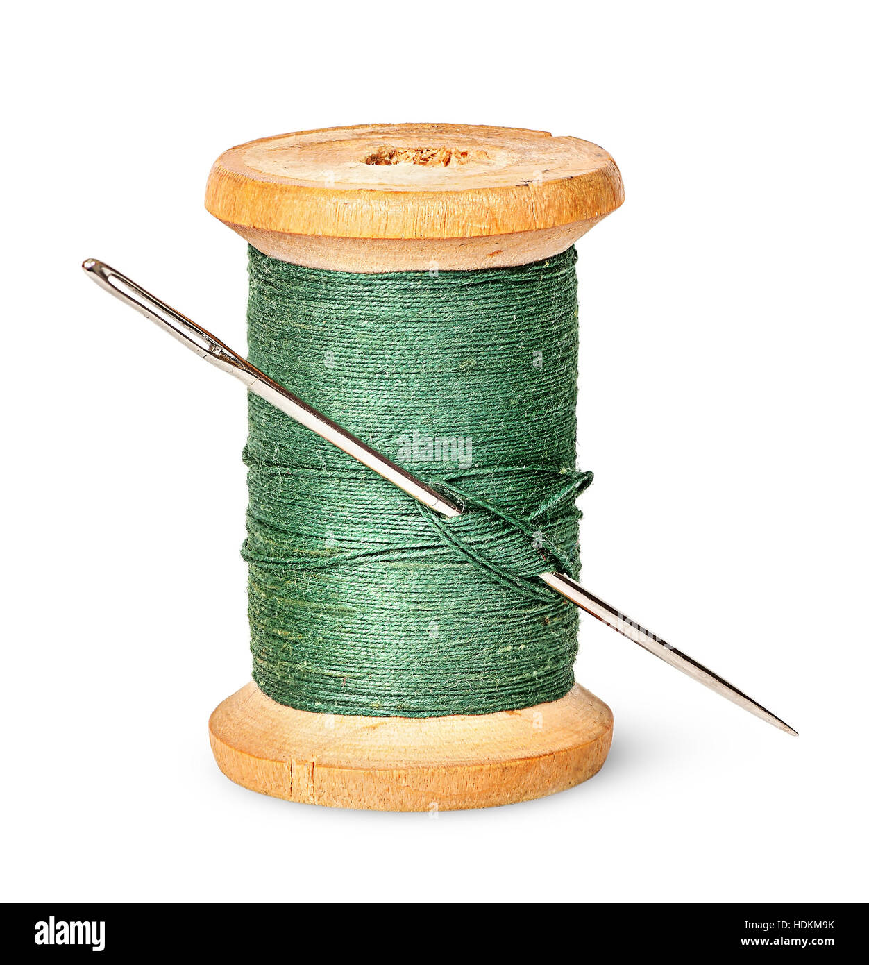 Needle and thread on wooden spool vertically isolated on white background Stock Photo