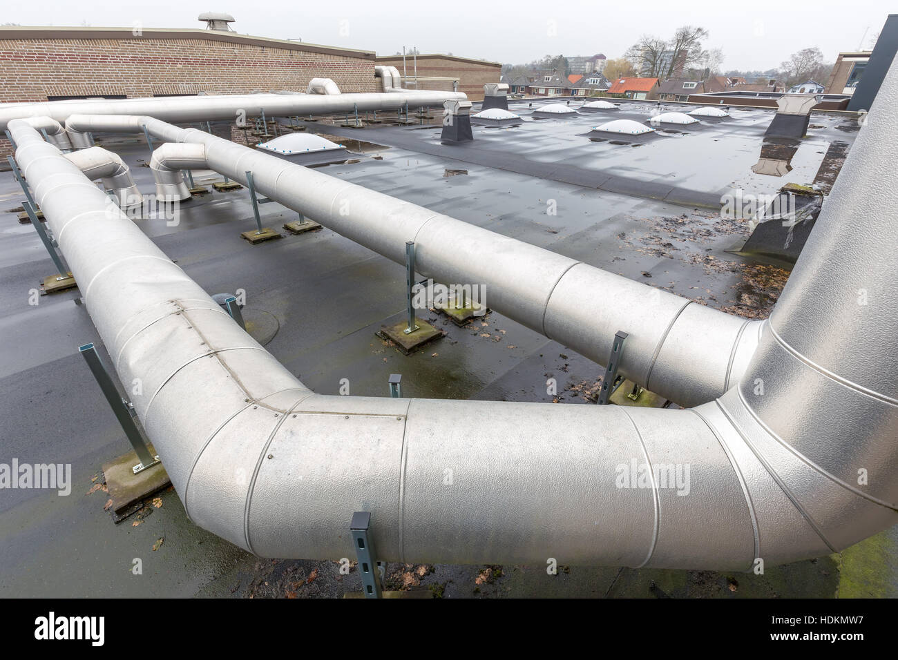Metal pipes for ventilation system on flat roof of school Stock Photo