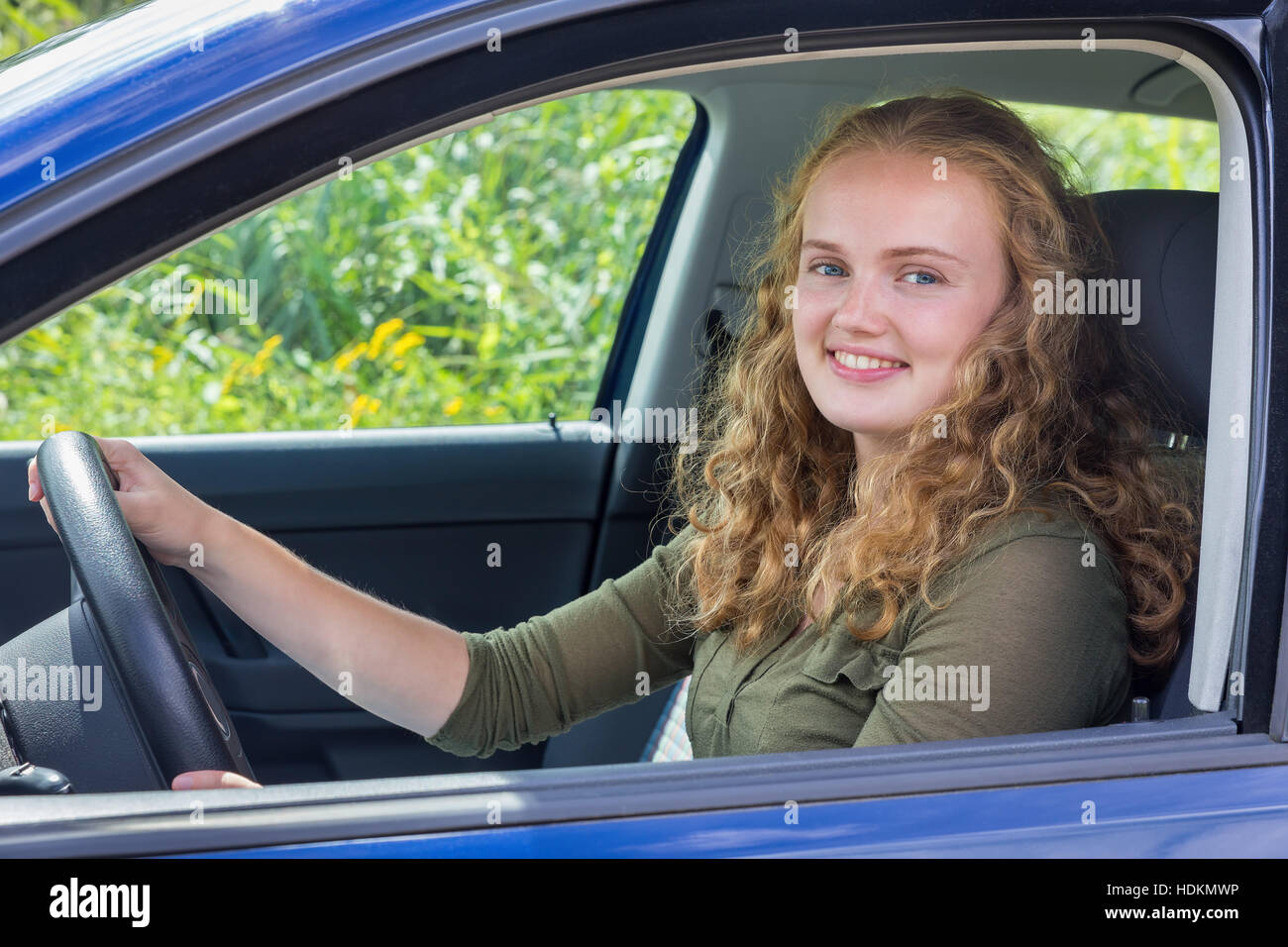 Portrait of young dutch woman holding steering wheel driving car Stock Photo
