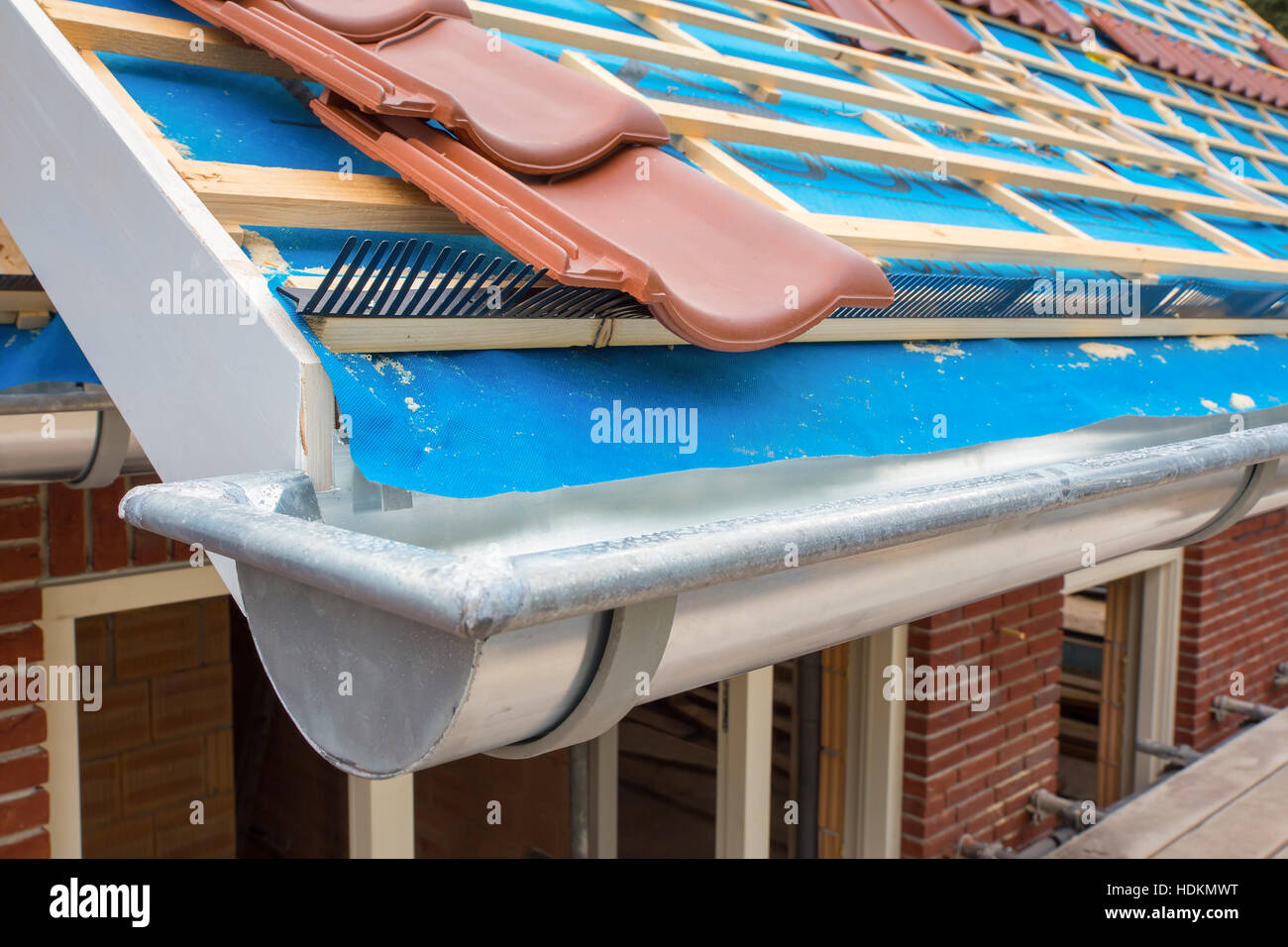 Zinc gutter and roof tiles on new house Stock Photo