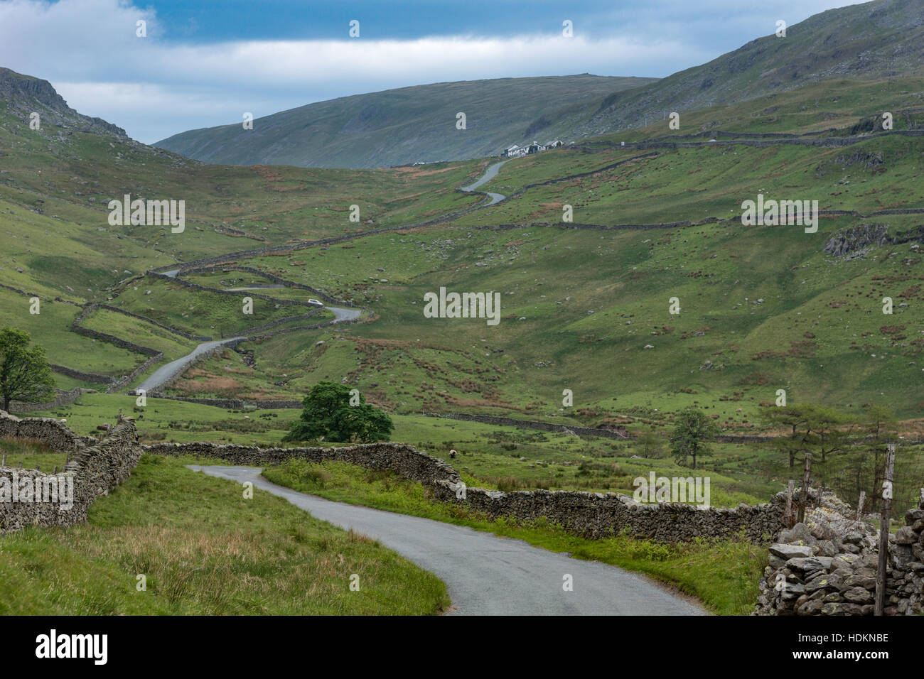 Long road winds through wide Lake District landscape. Stock Photo