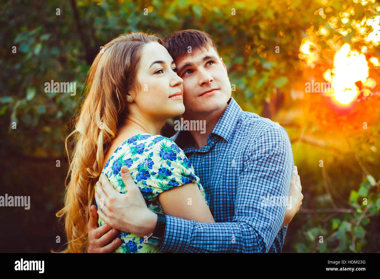 Loving couple embracing sitting in the woods Stock Photo - Alamy
