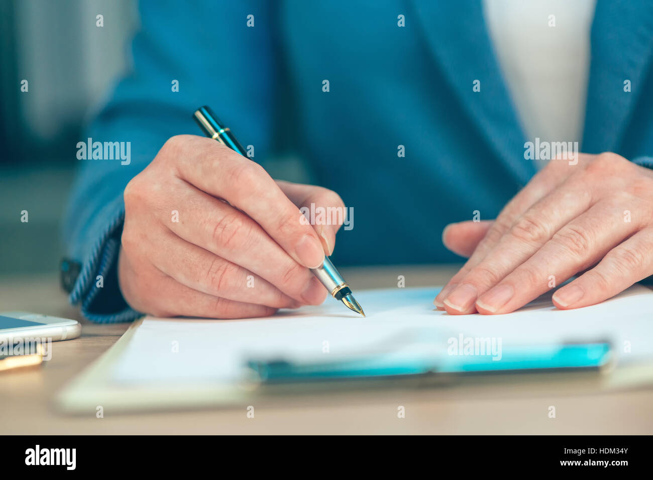 Businesswoman signing business contract agreement at office desk Stock Photo