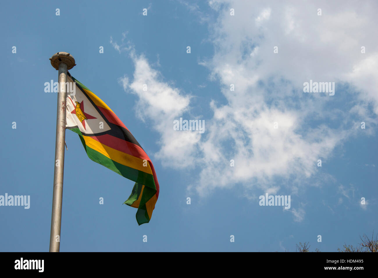 Zimbabwe flag flying fluttering blue sky clouds Stock Photo