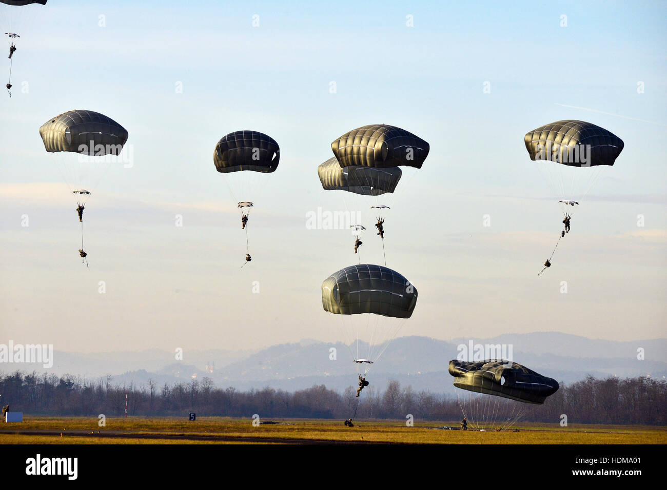 U.S. paratrooper soldiers parachute from a Lockheed C-130 Hercules transport aircraft during Exercise Mountain Shock at the Cerklje Drop Zone December 1, 2016 in Cerklje Ob Krki, Slovenia. Stock Photo