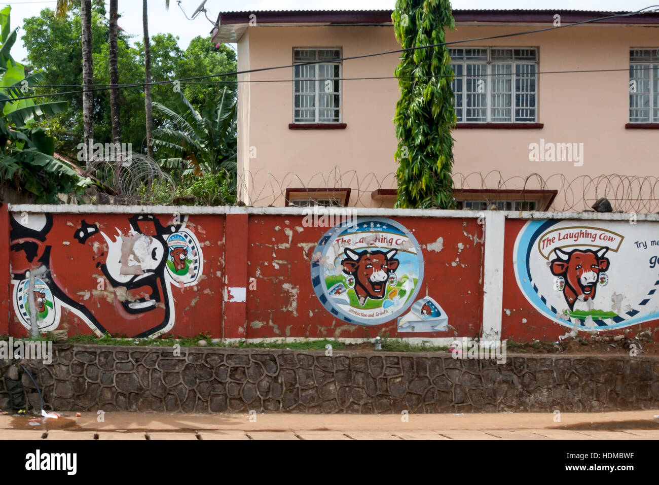 A mural for the cheese brand "La vache qui rit" (Laughing Cow) decorates a house wall in Freetown. Stock Photo
