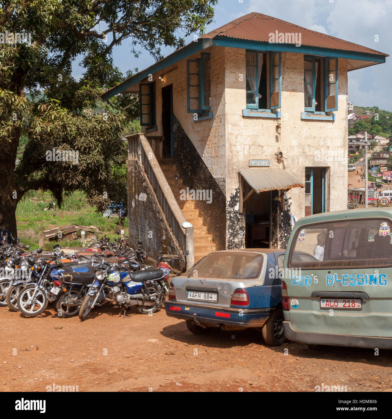 Motor Bicycles and cars parking in front of little house in Freetown