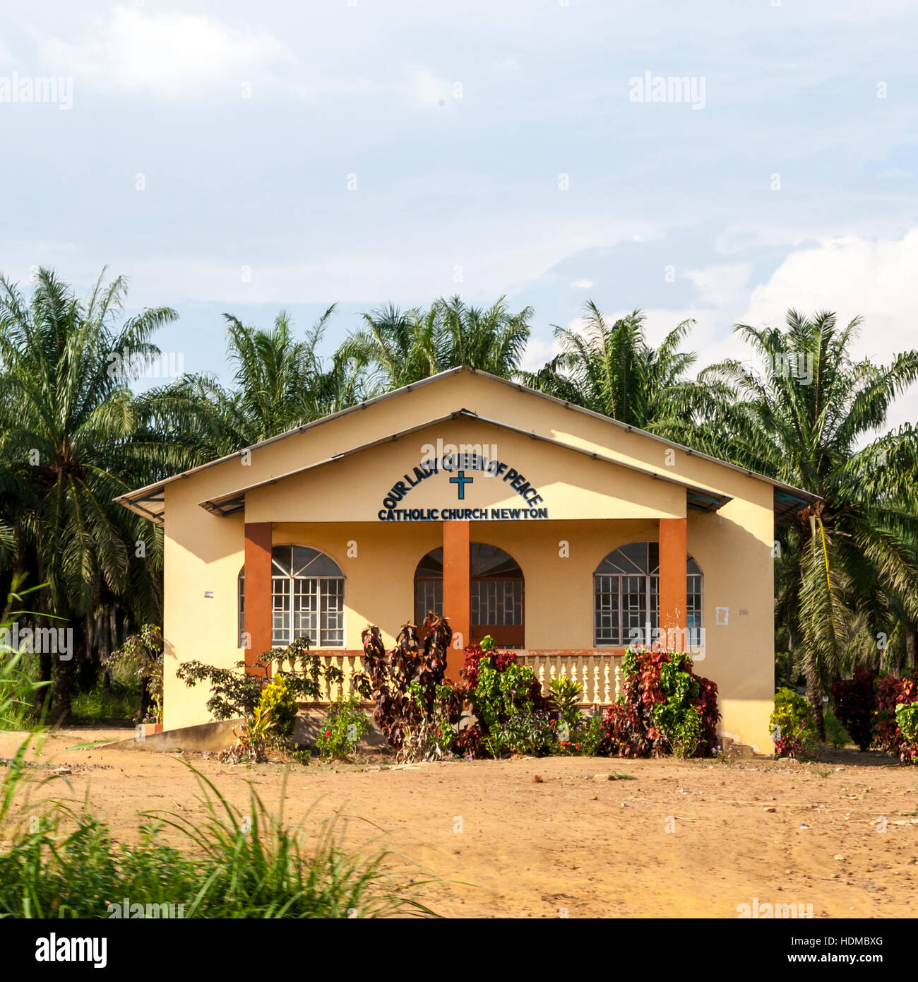The Catholic church "Our Lady Queen of Peace" stands among palm trees in Newton, Sierra Leone. Stock Photo