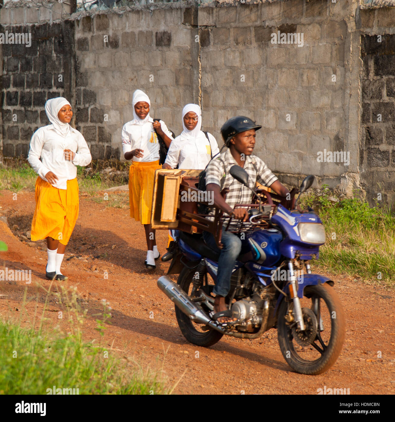 Okada (motobicycle taxi) in front of moslem students in Kenema, Sierra Leone Stock Photo