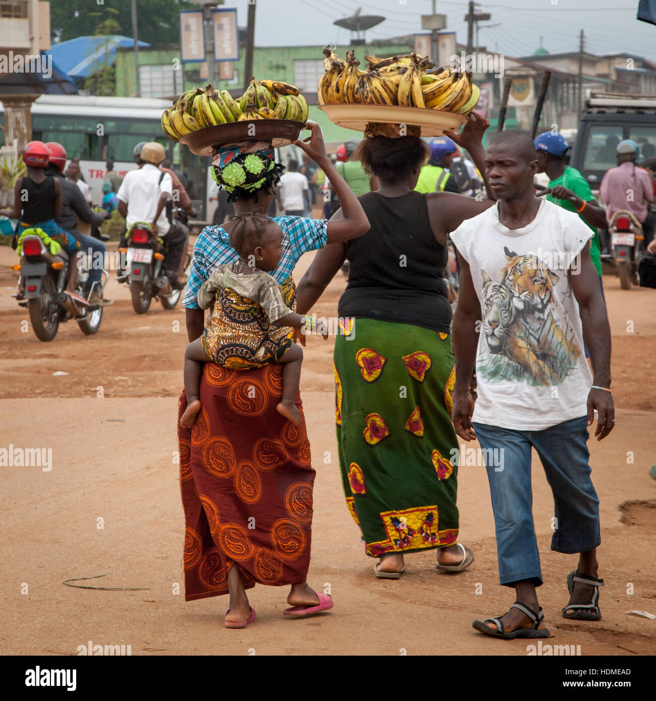 African women carrying bananas and a baby Stock Photo