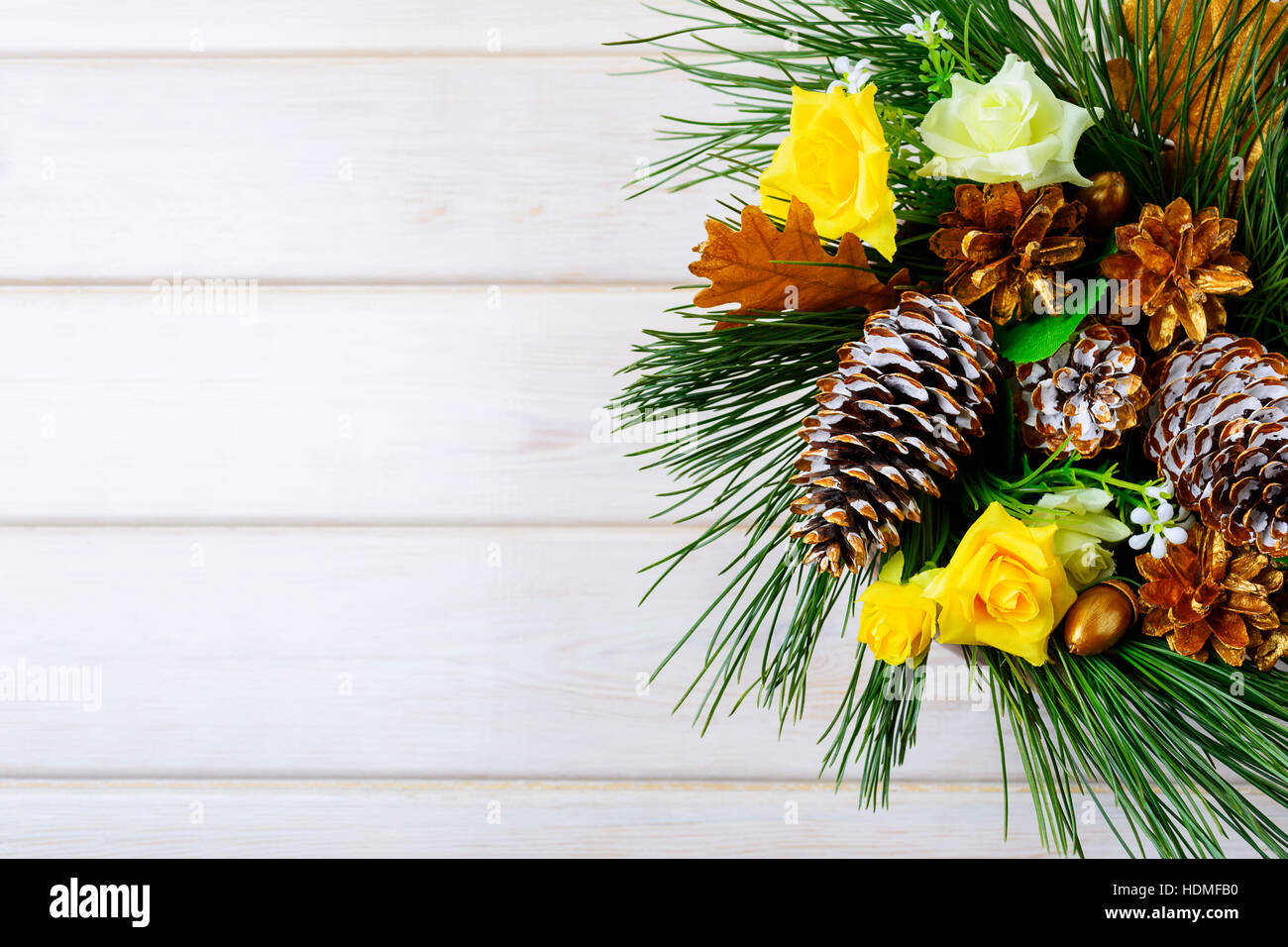 Christmas background with golden pine cones and yellow fabric roses ...