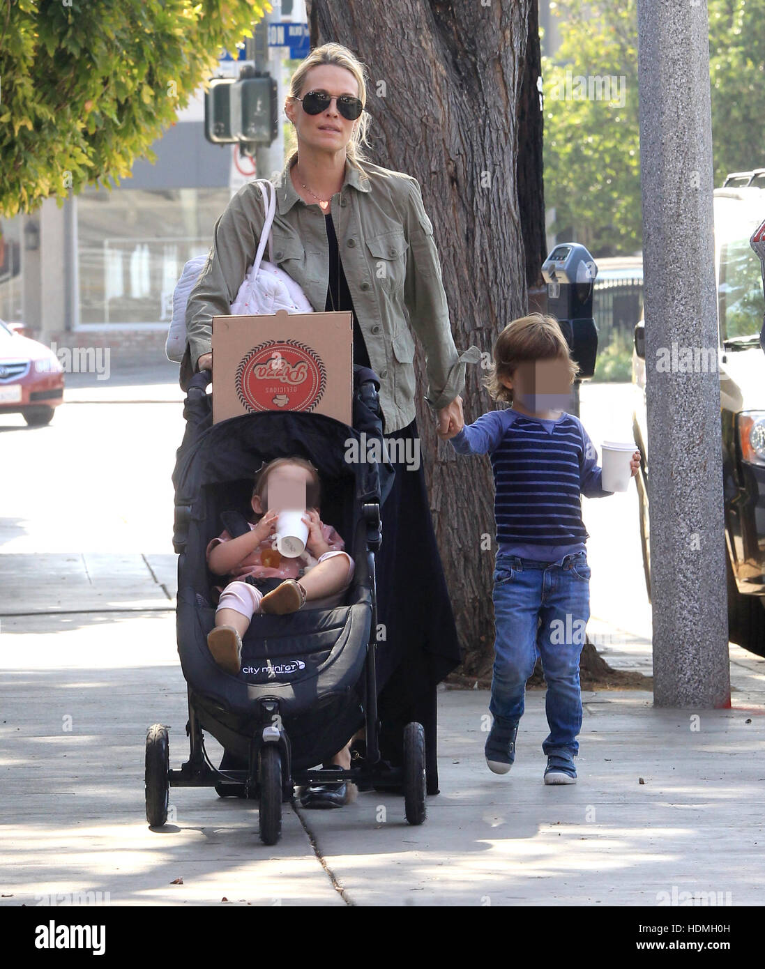 A pregnant Molly Sims leaves a pizza restaurant with her two children