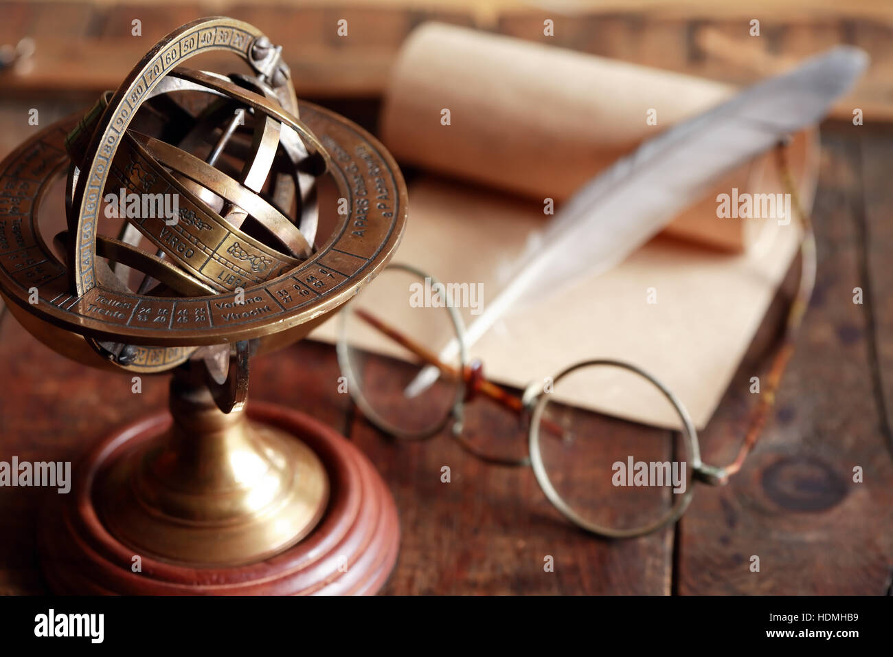 Vintage still life with Armillary sphere globe near quill and scroll Stock Photo