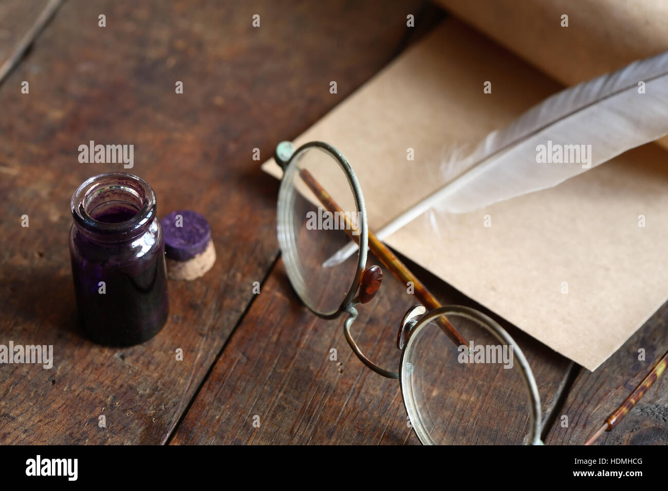 Paper and quill pen near spectacles on nice old wooden background Stock Photo